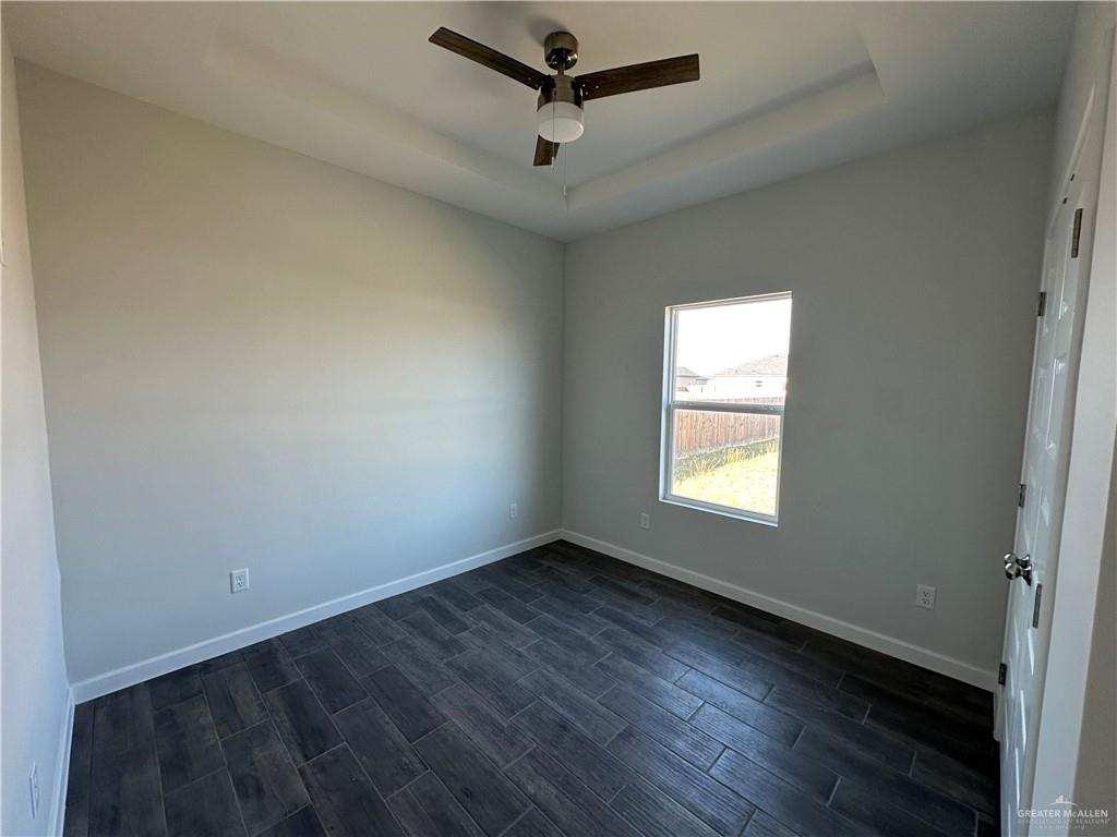 1703 Unity Drive Mercedes, TX 78570 - Photo 7 of 10 an empty room with wooden floor and windows