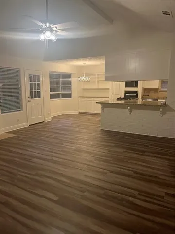 a view of a kitchen with stainless steel appliances wooden floor and cabinets