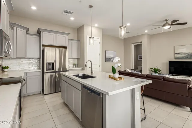a kitchen with a sink a counter top space stainless steel appliances and cabinets