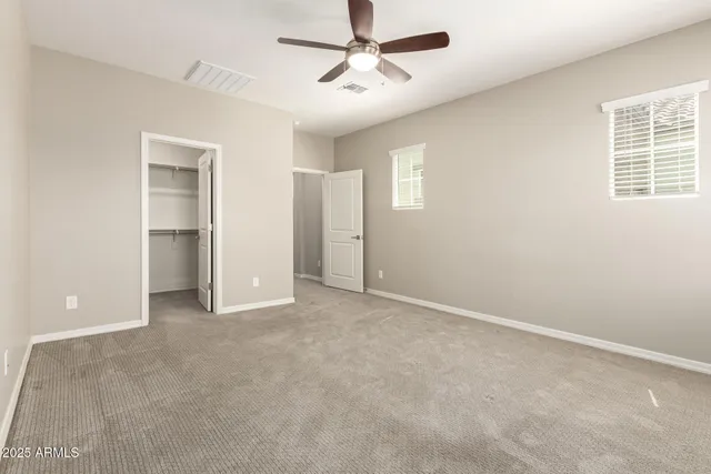 an empty room with closet and windows