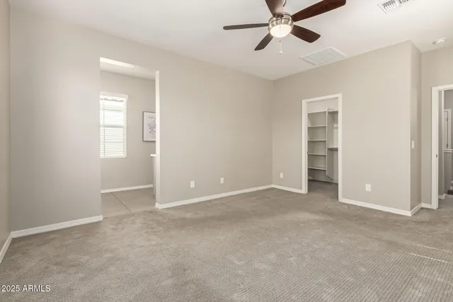 an empty room with closet and windows