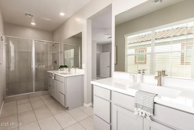 a bathroom with a sink shower and a mirror