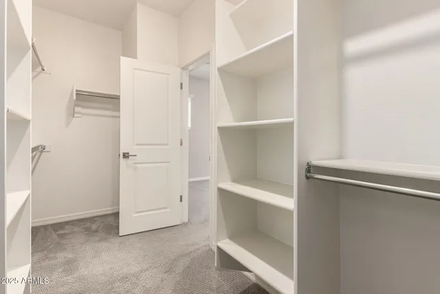a view of walk in closet with empty racks