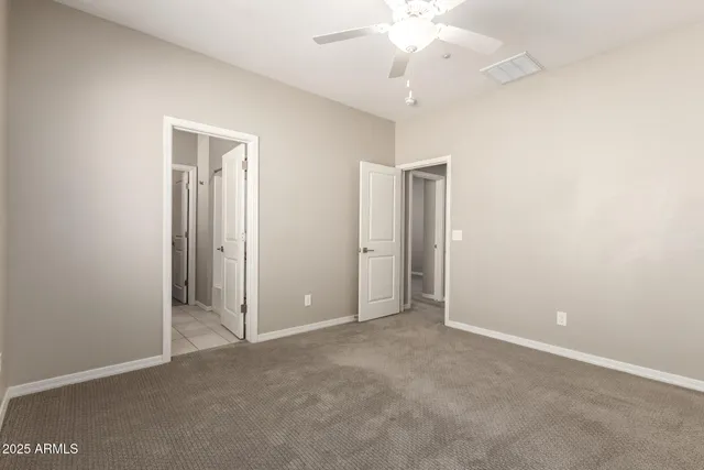 an empty room with a fan & a ceiling fan
