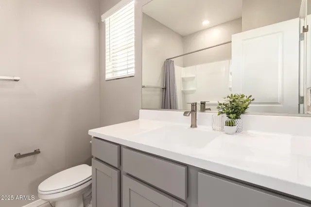 a bathroom with a sink a toilet and mirror
