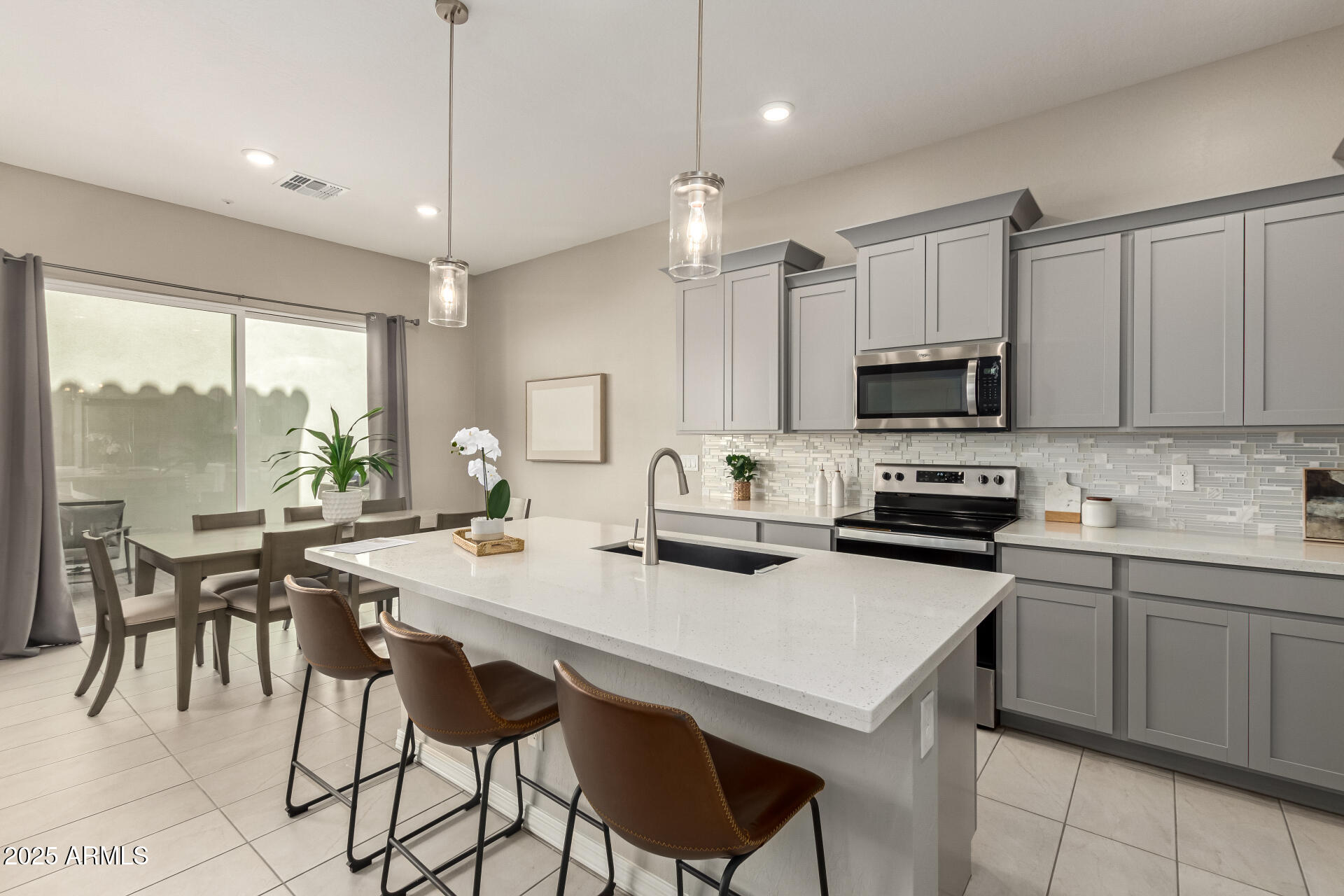 1535 East Dublin Street Gilbert, AZ 85295 - Photo 10 of 31 a kitchen with kitchen island a stove a sink a dining table and chairs