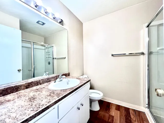 a bathroom with a granite countertop sink toilet and shower