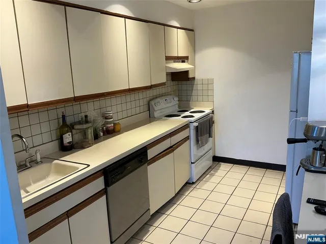 a kitchen with stainless steel appliances a sink stove and cabinets