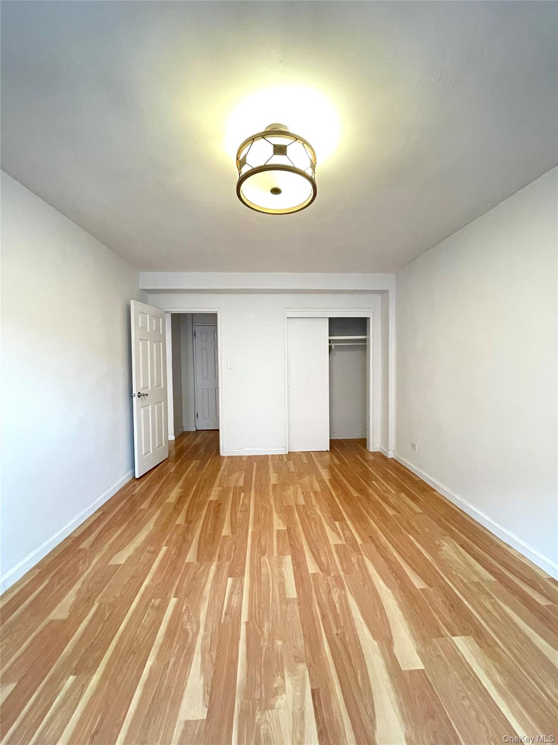136-04 Cherry Avenue, Unit 3I Queens, NY 11355 - Photo 7 of 7 a view of empty room with wooden floor
