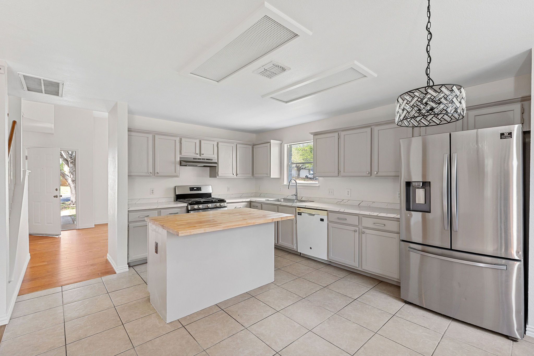 501 Shep Street Austin, TX 78748 - Photo 17 of 40 a kitchen with stainless steel appliances granite countertop a refrigerator a sink dishwasher a stove with white cabinets