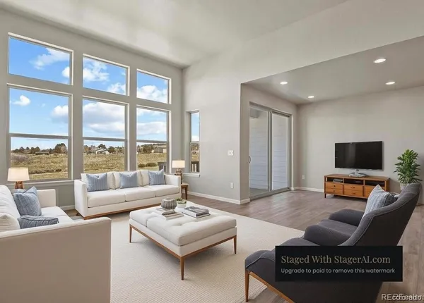 a living room with furniture a floor to ceiling window and a flat screen tv