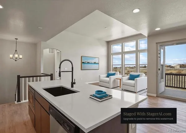 a kitchen with a sink a counter top space and living room view