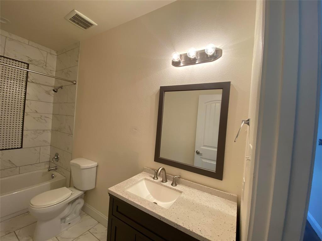 3912 Avant Street Dallas, TX 75215 - Photo 21 of 27 a bathroom with a sink a toilet and a mirror