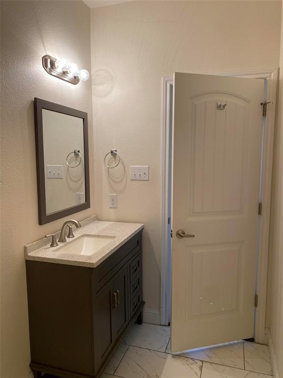 3912 Avant Street Dallas, TX 75215 - Photo 23 of 27 a bathroom with a double vanity sink and a mirror
