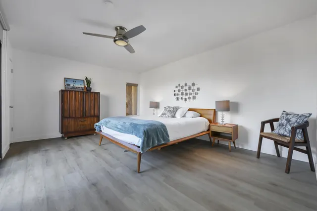 a bedroom with a large bed and a chandelier