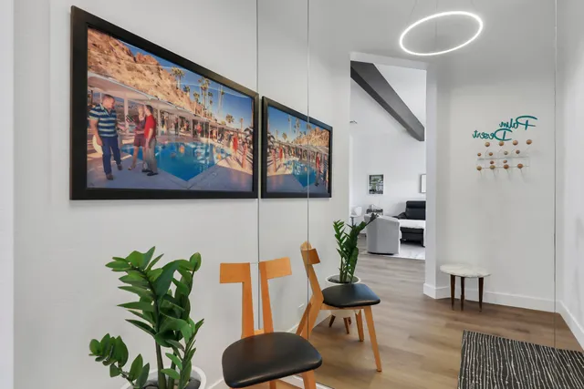 a living room with furniture and a painting on the wall