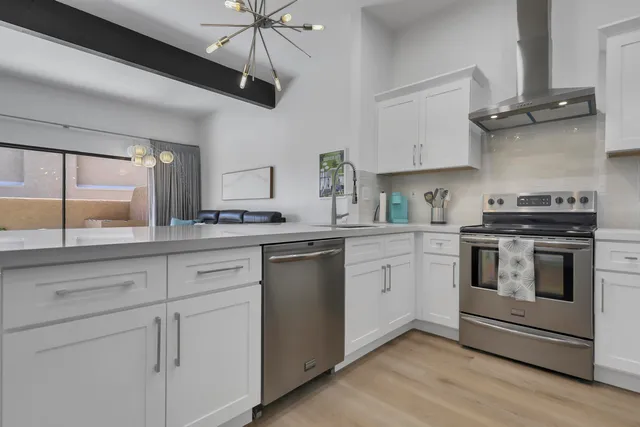 a kitchen with cabinets stainless steel appliances and wooden floor