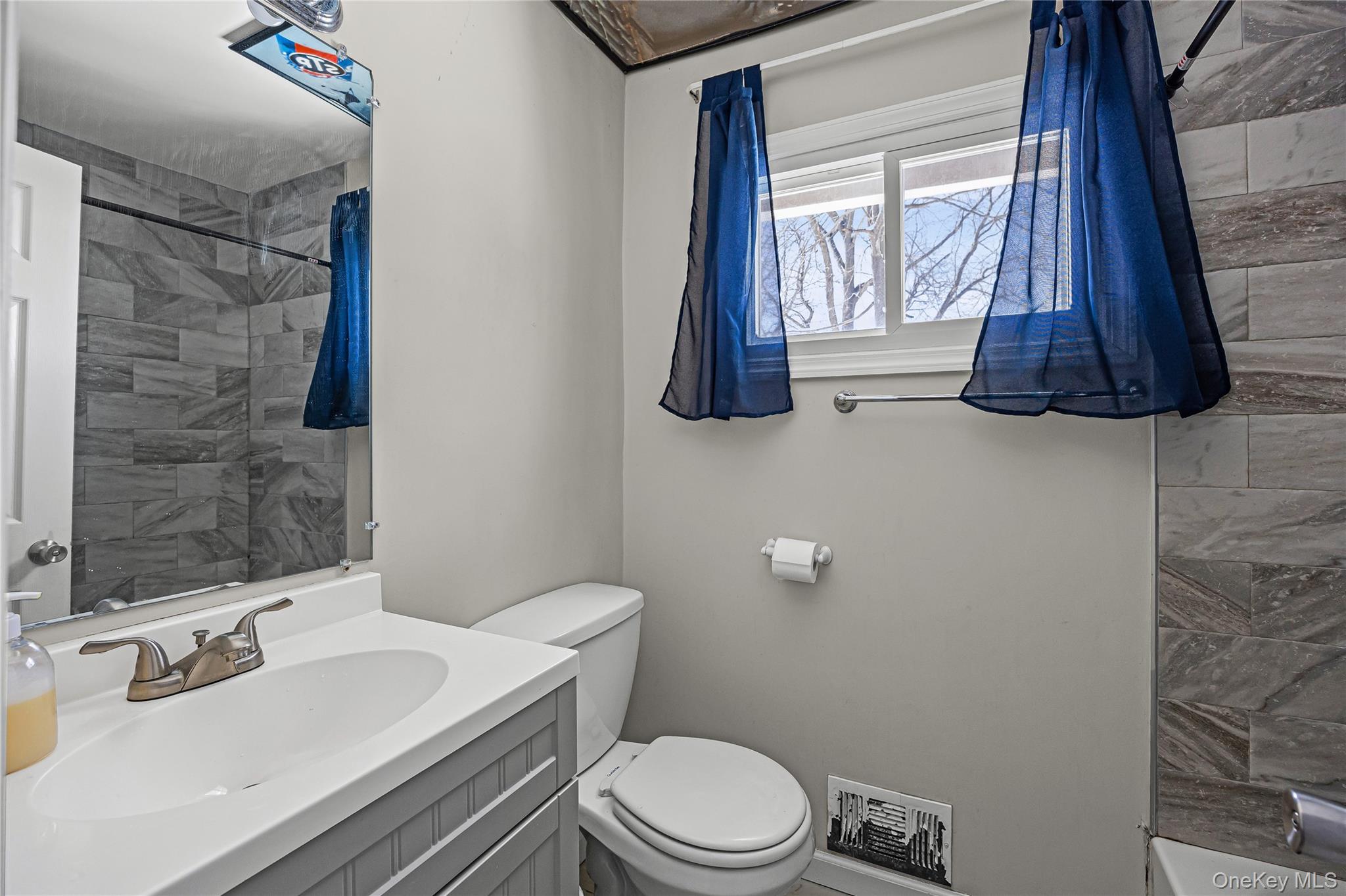 183 Mark Tree Road Centereach, NY 11720 - Photo 8 of 10 a bathroom with a toilet sink and shower curtain