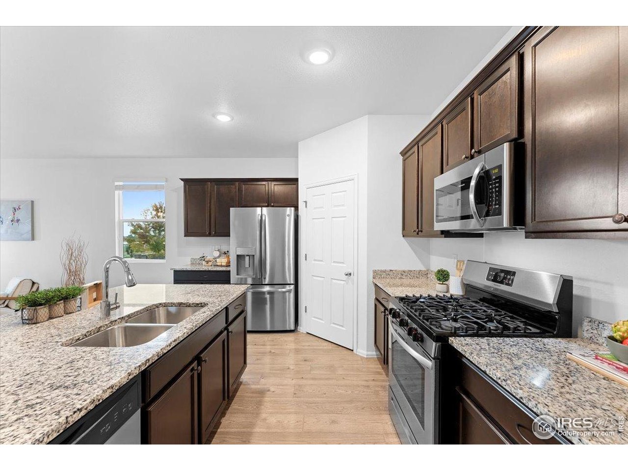 501 Buckrake Street Severance, CO 80550 - Photo 14 of 50 a kitchen with stainless steel appliances granite countertop a sink stove microwave and refrigerator