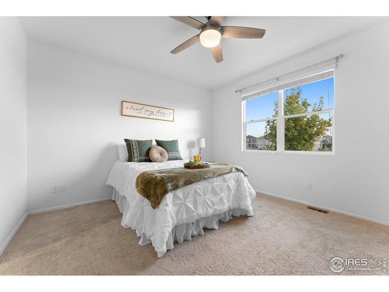 501 Buckrake Street Severance, CO 80550 - Photo 32 of 50 a bedroom with a large bed and a chandelier