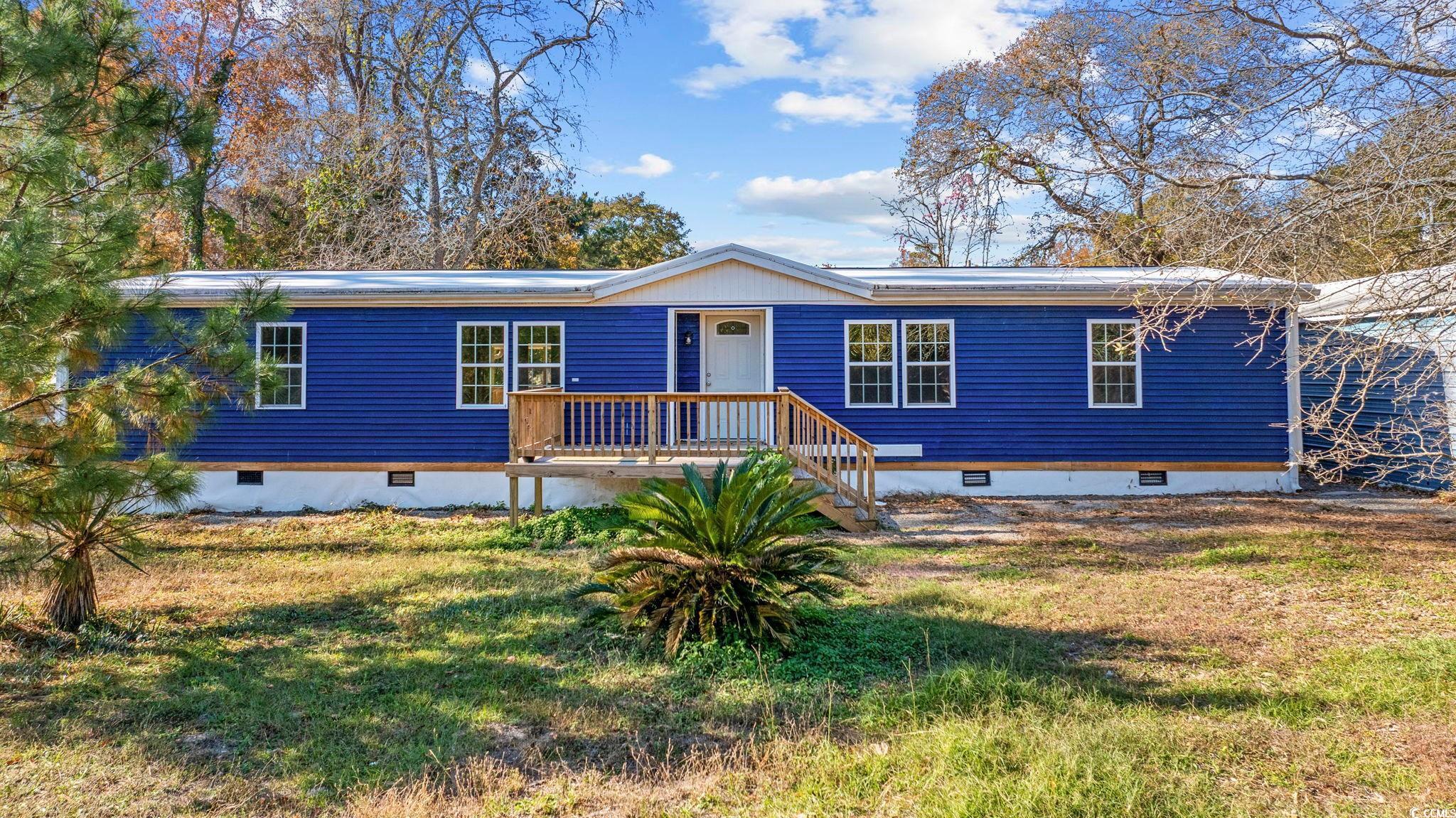 View of front facade with crawl space and a front yard
