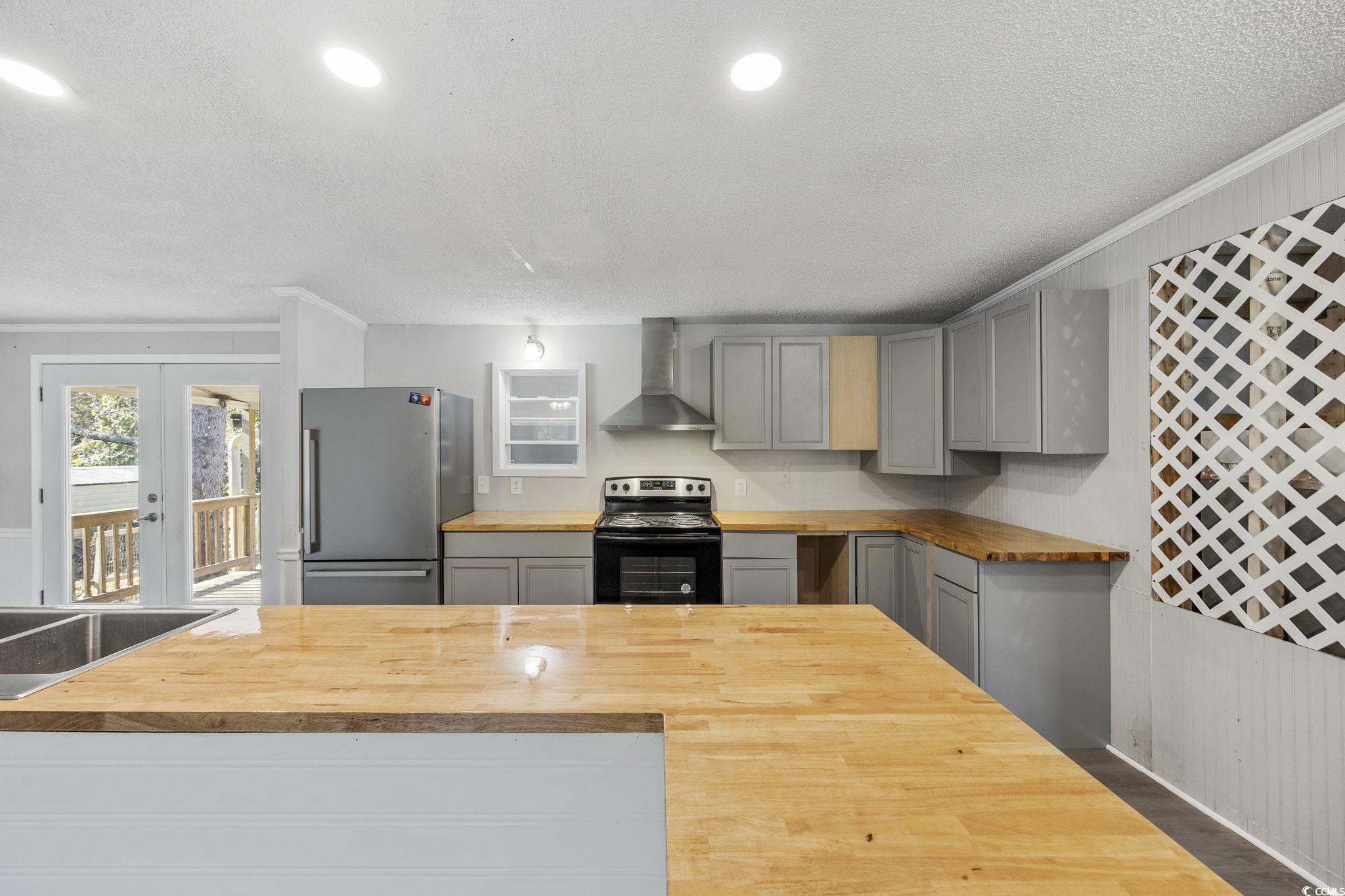 4221 Blake Road Myrtle Beach, SC 29588 - Photo 11 of 36 Kitchen featuring wooden counters, gray cabinetry, a textured ceiling, freestanding refrigerator, and black electric range oven