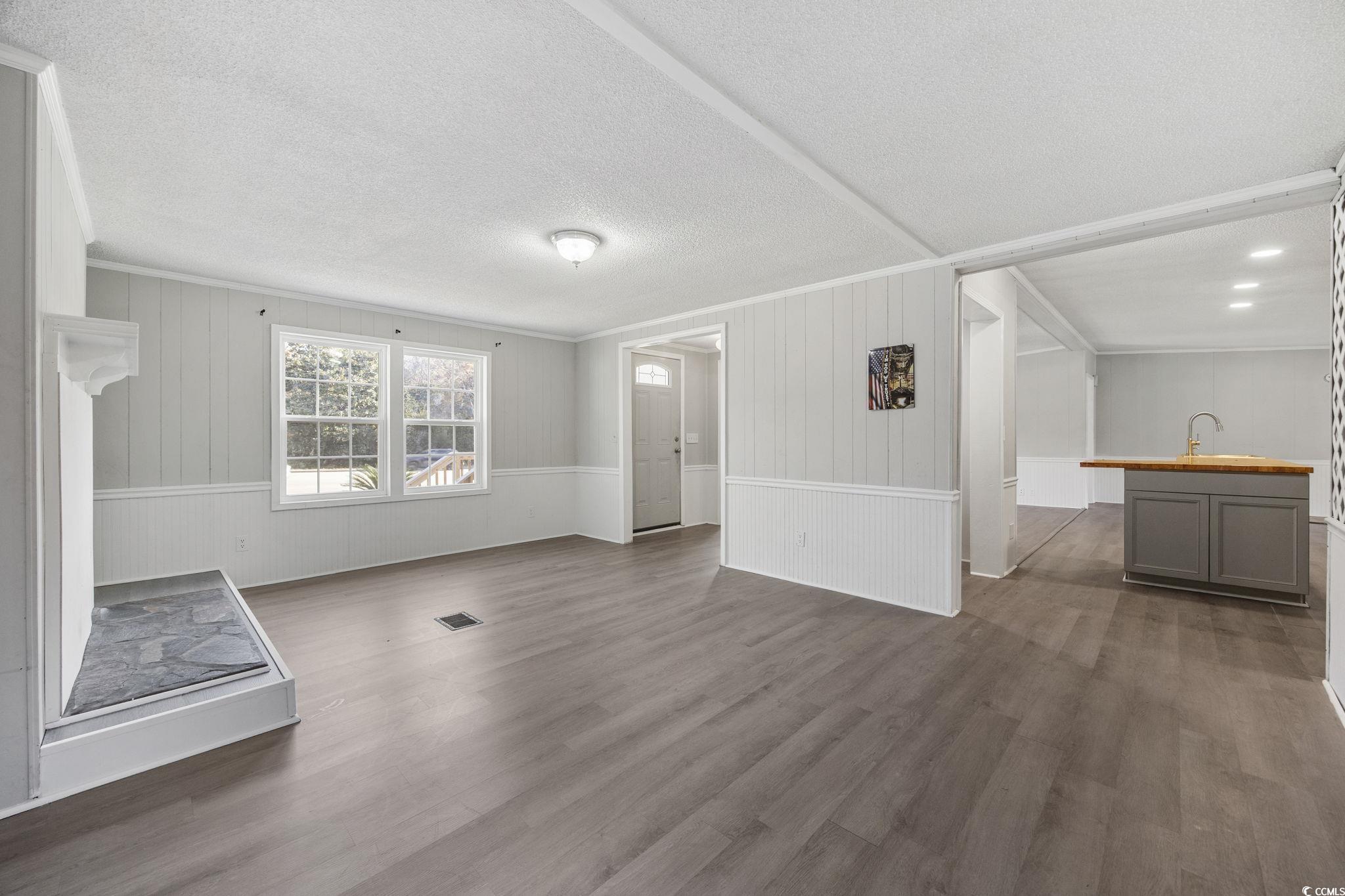 4221 Blake Road Myrtle Beach, SC 29588 - Photo 14 of 36 Unfurnished living room featuring dark wood-style floors, a textured ceiling, and crown molding