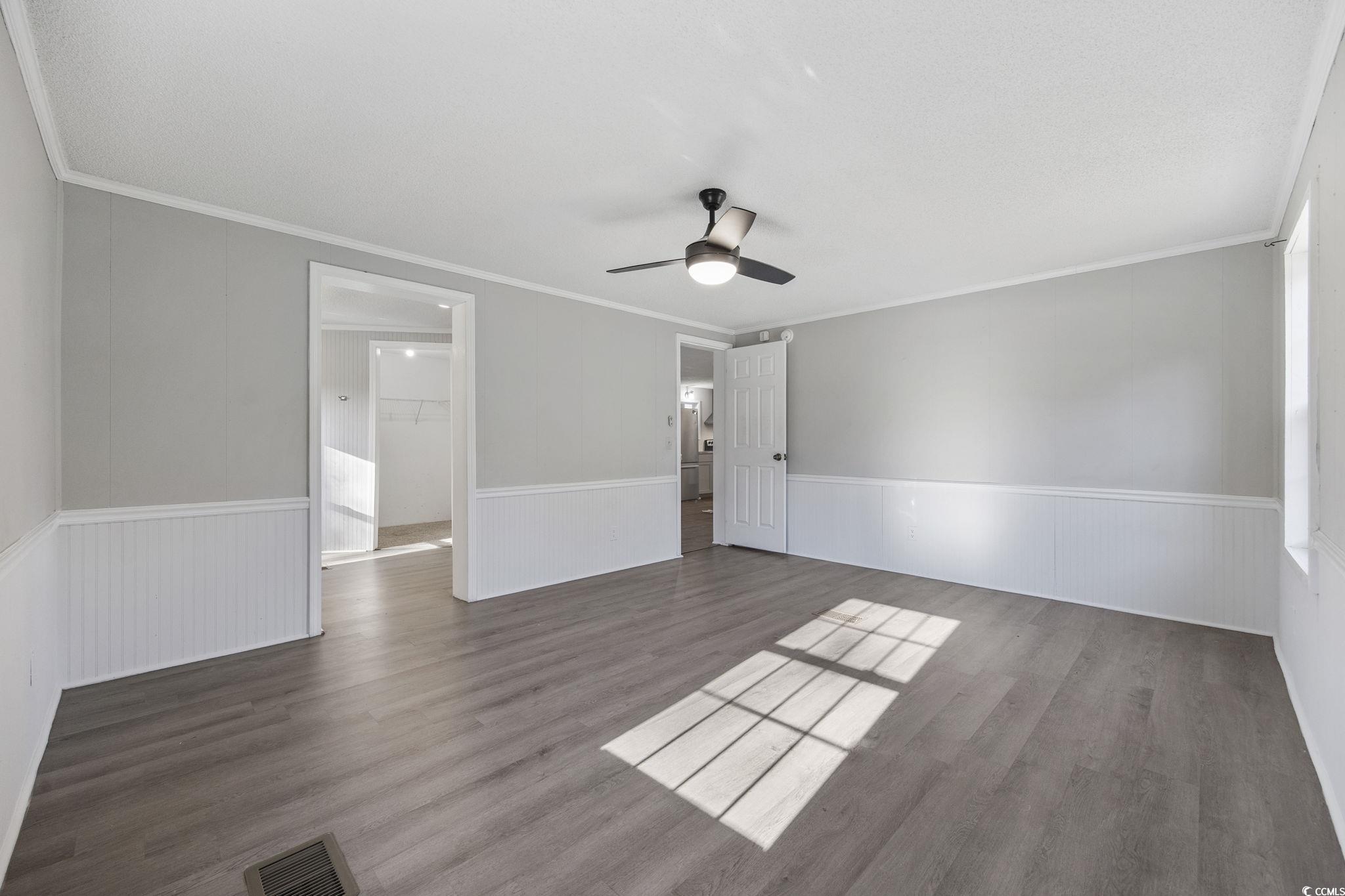 4221 Blake Road Myrtle Beach, SC 29588 - Photo 16 of 36 Unfurnished bedroom with wood finished floors, crown molding, a ceiling fan, and a wainscoted wall