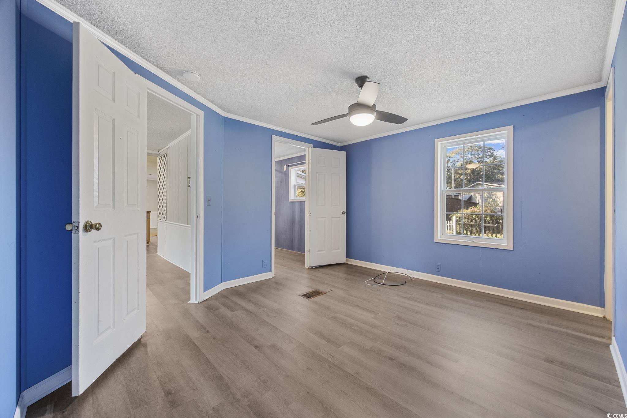 4221 Blake Road Myrtle Beach, SC 29588 - Photo 20 of 36 Unfurnished bedroom featuring wood finished floors, ceiling fan, a textured ceiling, and ornamental molding