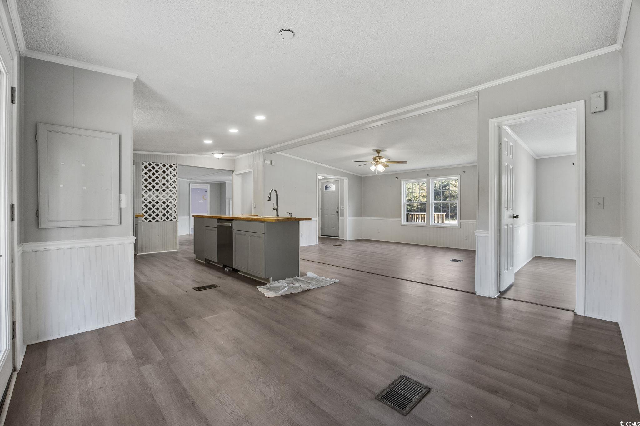 4221 Blake Road Myrtle Beach, SC 29588 - Photo 6 of 36 Kitchen with a wainscoted wall, ornamental molding, gray cabinets, an island with sink, and dark wood-style floors