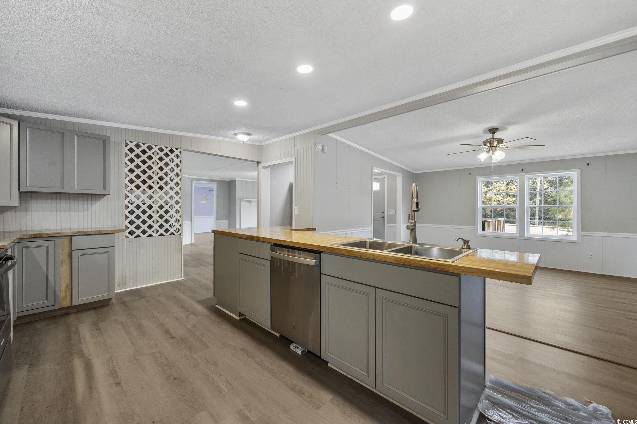 4221 Blake Road Myrtle Beach, SC 29588 - Photo 8 of 36 Kitchen with gray cabinets, a center island with sink, light wood finished floors, wainscoting, and crown molding