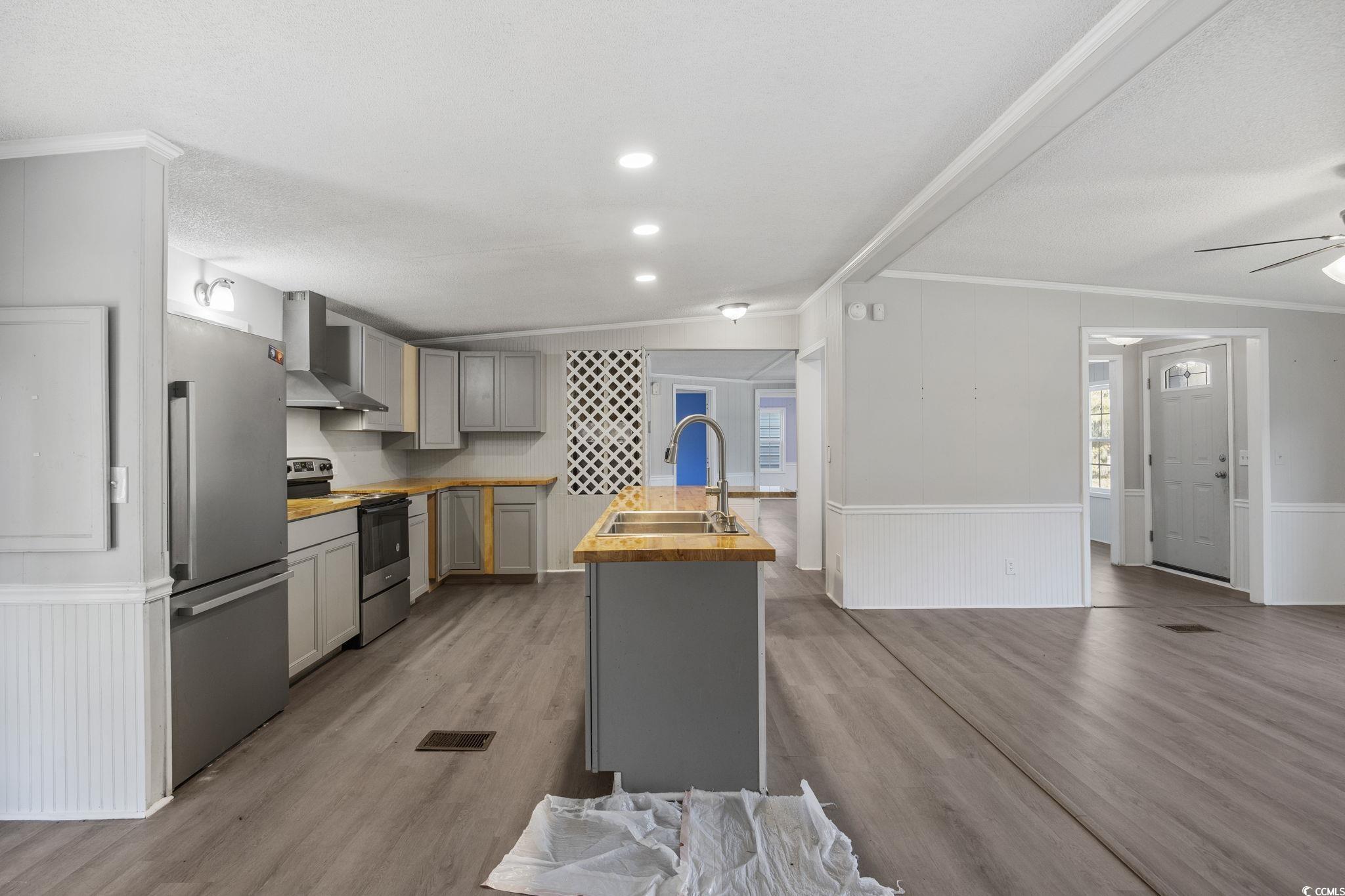 4221 Blake Road Myrtle Beach, SC 29588 - Photo 9 of 36 Kitchen featuring wainscoting, gray cabinets, wooden counters, crown molding, and appliances with stainless steel finishes