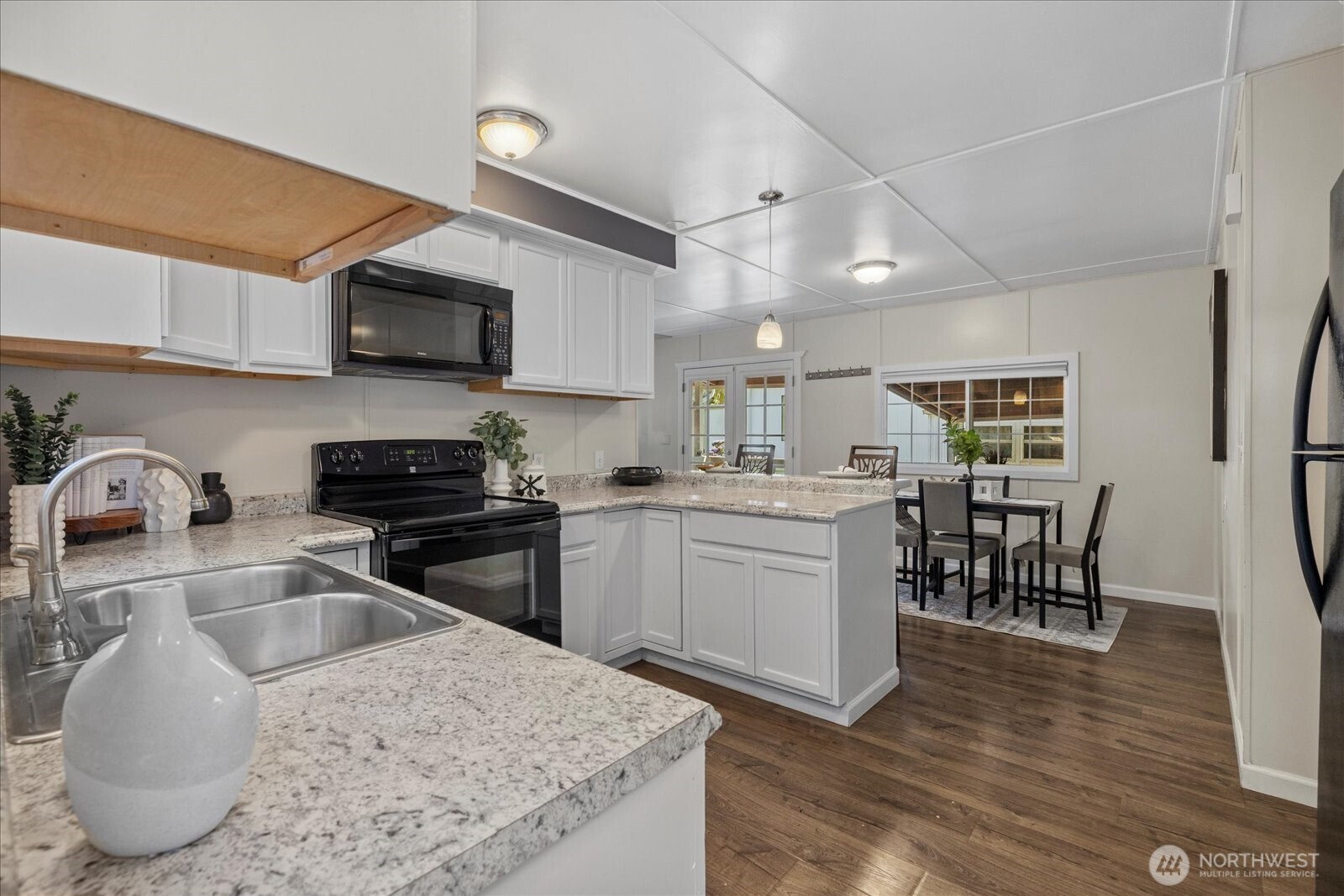7301 Northeast 175th Street Kenmore, WA 98028 - Photo 13 of 28 a kitchen with stainless steel appliances granite countertop a sink dishwasher a stove top oven a refrigerator with island and chairs