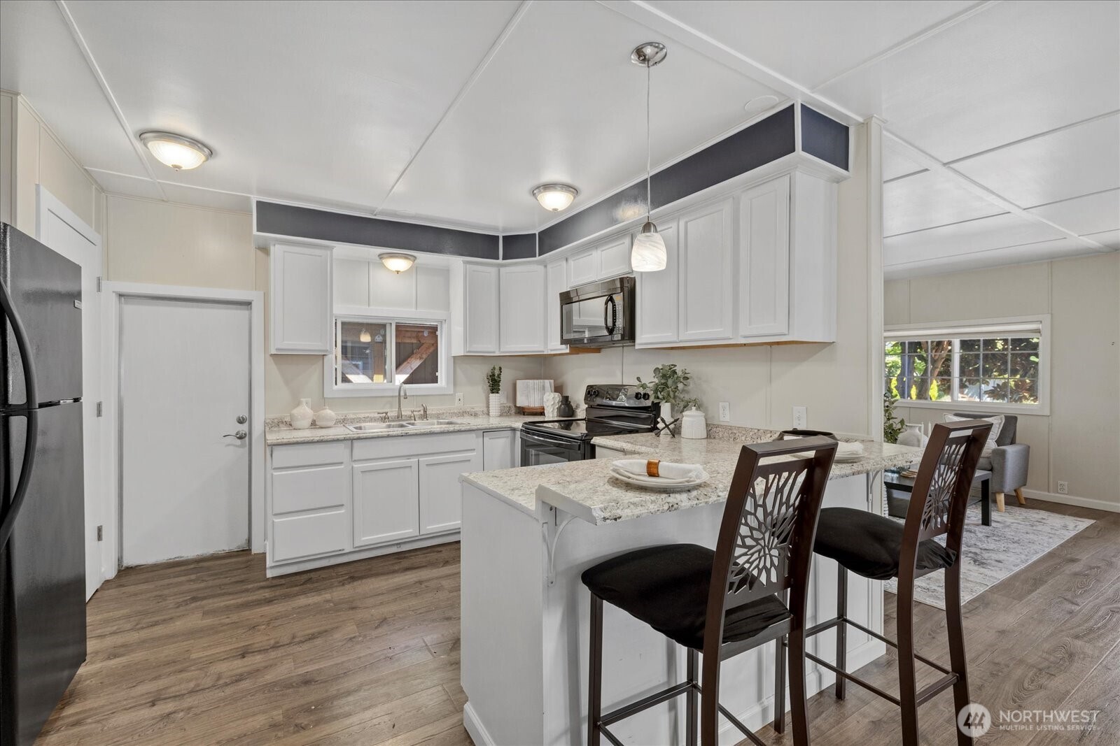 7301 Northeast 175th Street Kenmore, WA 98028 - Photo 14 of 28 a kitchen with kitchen island granite countertop a table chairs microwave and cabinets