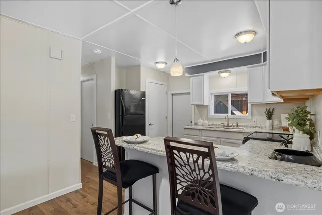 a kitchen with a table chairs refrigerator and microwave