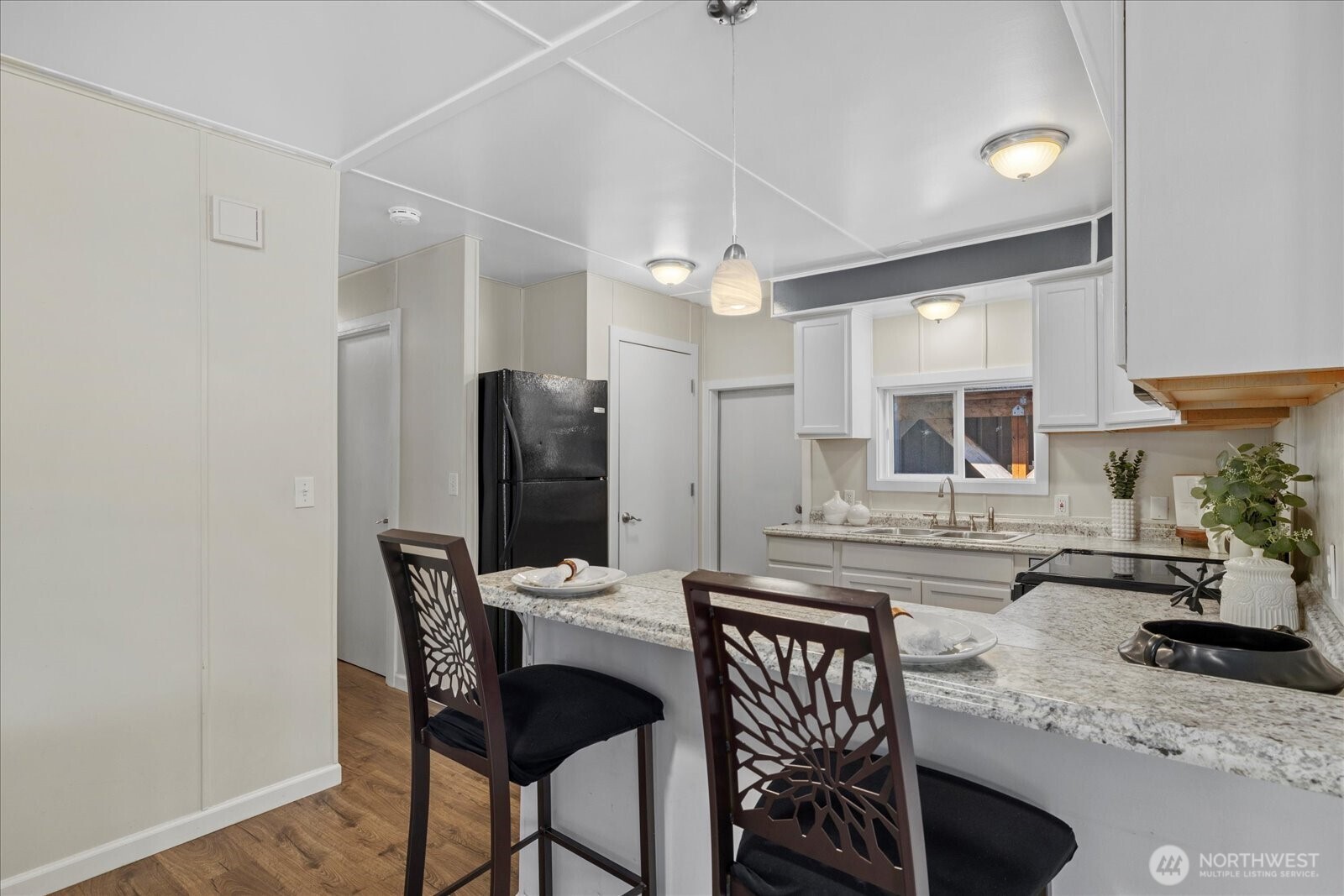 7301 Northeast 175th Street Kenmore, WA 98028 - Photo 15 of 28 a kitchen with a table chairs refrigerator and microwave