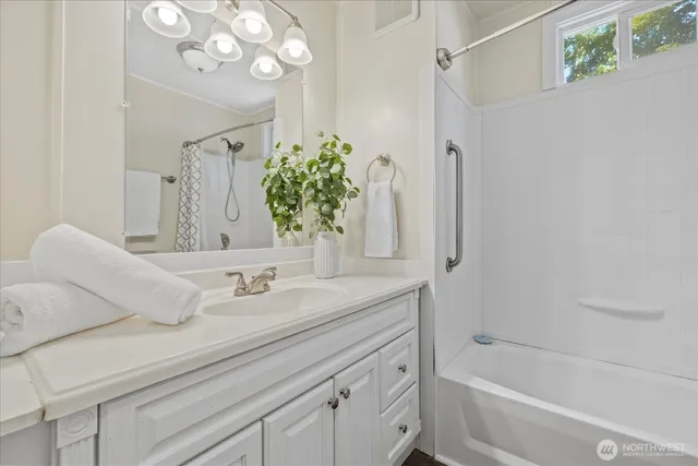a bathroom with a granite countertop sink a toilet and shower