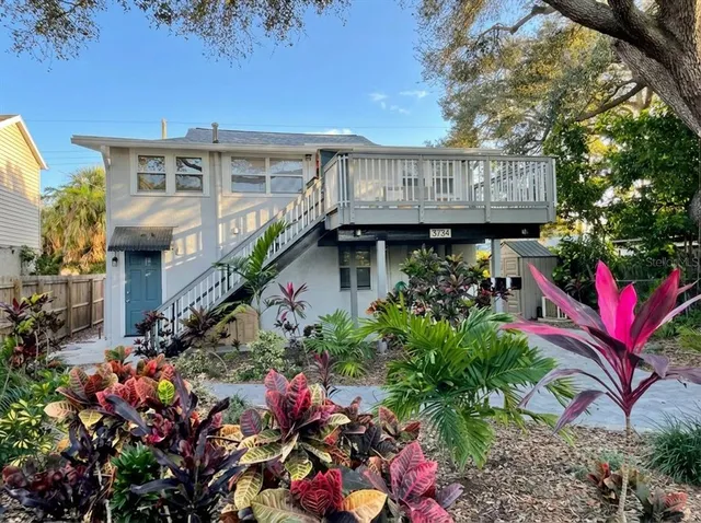 a view of a house with lots of flower plants