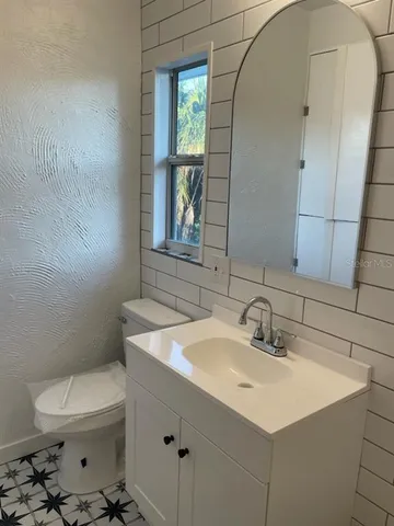 a bathroom with a sink toilet and mirror