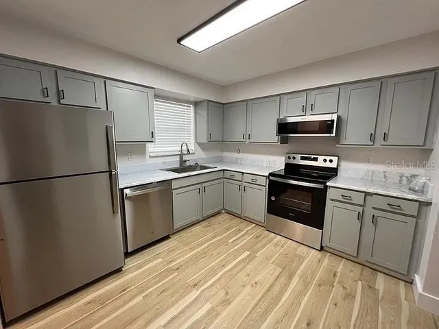a kitchen with a sink appliances and cabinets