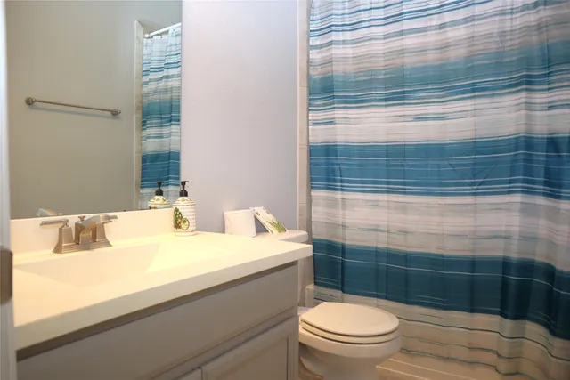 a kitchen with stainless steel appliances granite countertop a refrigerator a sink dishwasher a stove and white cabinets with wooden floor