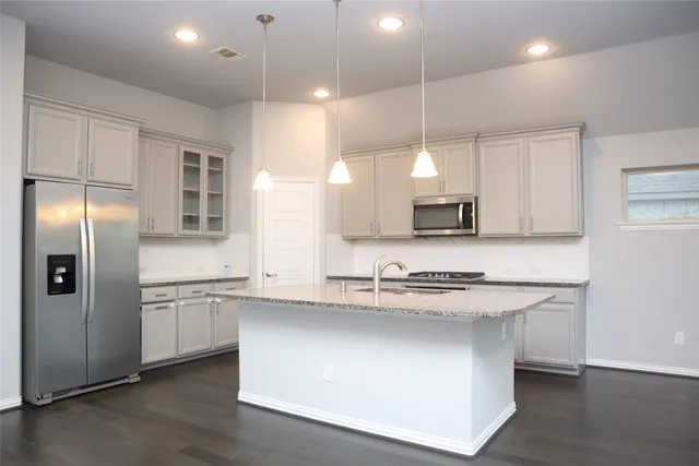 an empty room with wooden floor and entrance to ceiling window