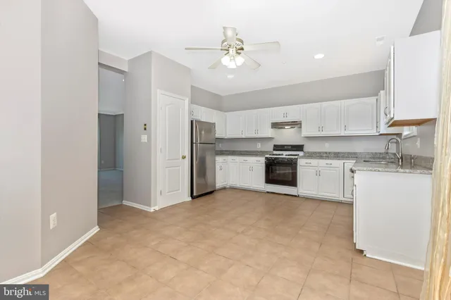 a kitchen with a stove sink and cabinets