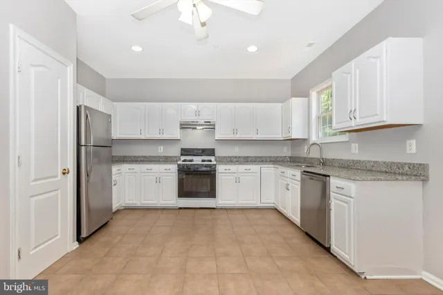 a kitchen with white cabinets and white appliances