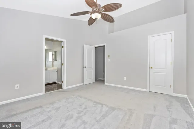 a view of an empty room and a ceiling fan