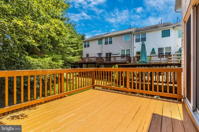 a view of a house with wooden deck and floor to ceiling window