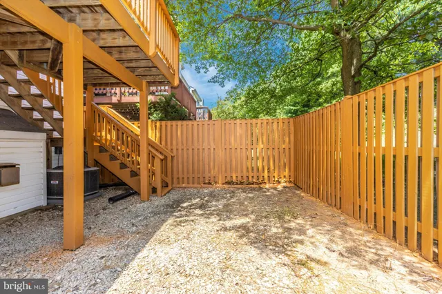 a view of a pathway with a small yard and wooden fence