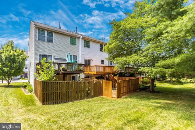 a view of a backyard with couches plants and large tree