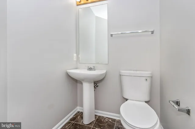 a bathroom with a sink toilet and a mirror