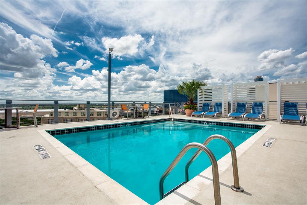 1122 Jackson Street, Unit 917 Dallas, TX 75202 - Photo 16 of 19 a view of a swimming pool with a table and chairs